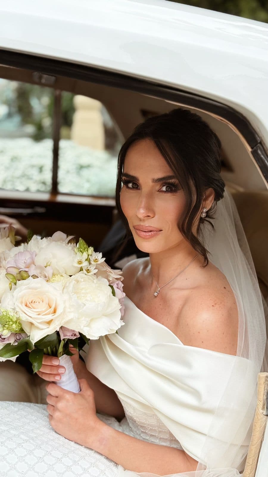 Novia con su ramo dentro del coche, camino de la ceremonia
